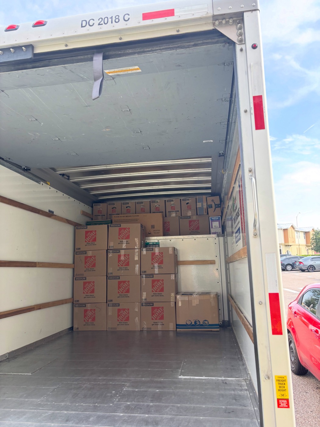 A moving truck packed floor to ceiling with tightly stacked boxes and furniture